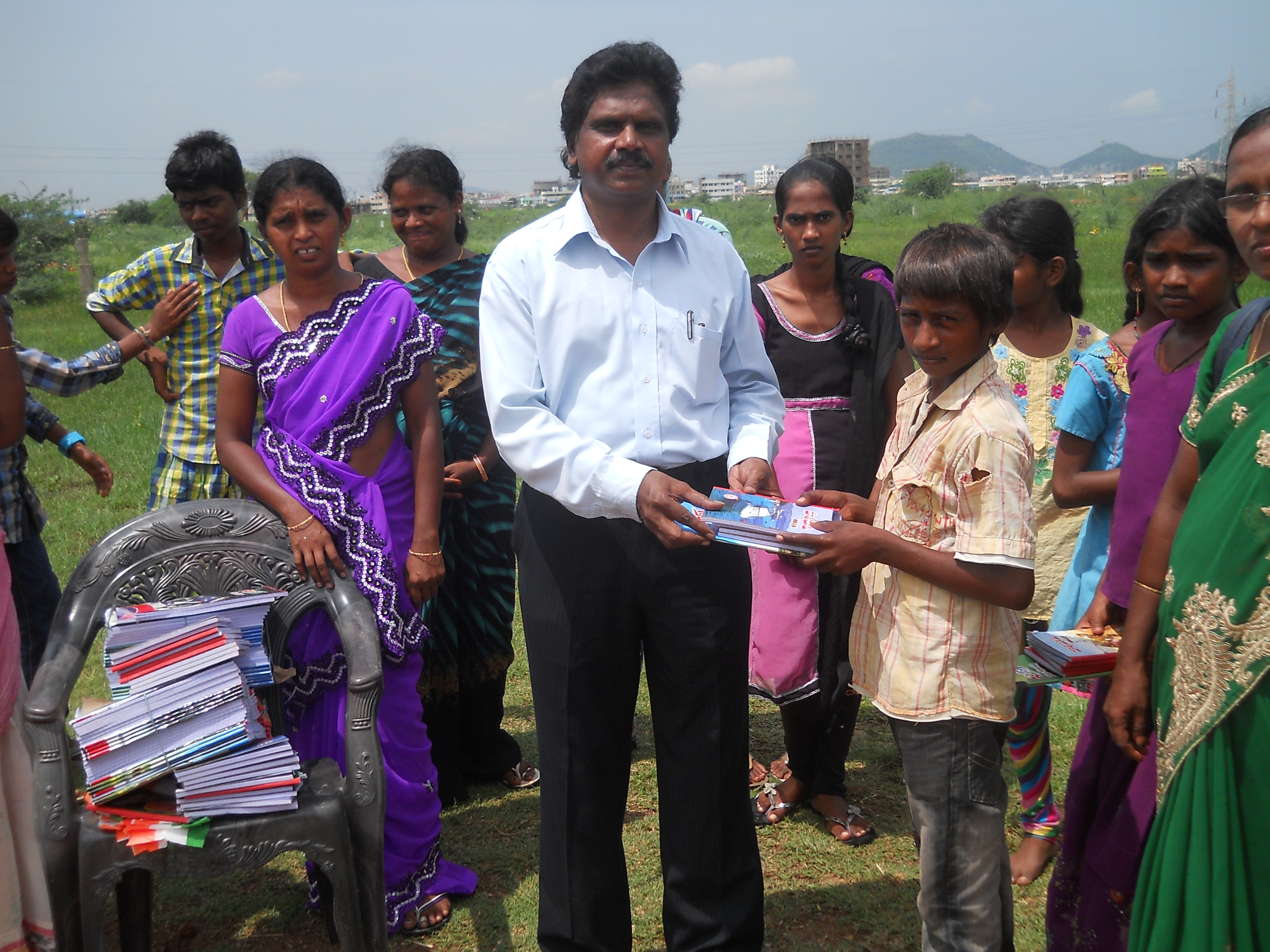 Paul Raj hands over notebooks to the students